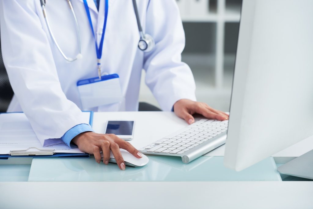 Hands of medical specialist working on computer